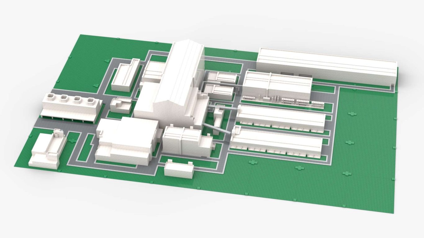 Maqueta de un complejo industrial con edificios en disposición ordenada sobre una base verde.
