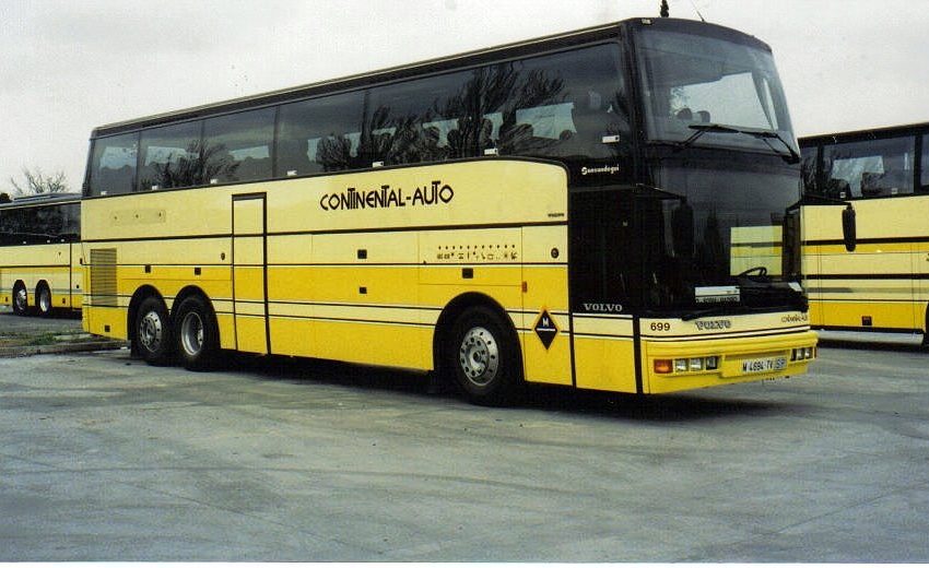 Autobús de dos pisos amarillo y negro aparcado en una terminal.