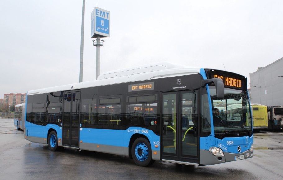 Autobús urbano de color azul y negro, estacionado en una terminal.