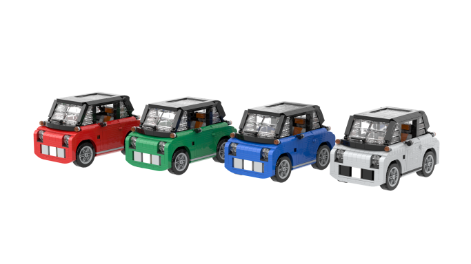 Cuatro autos de juguete de colores: rojo, verde, azul y blanco, alineados.