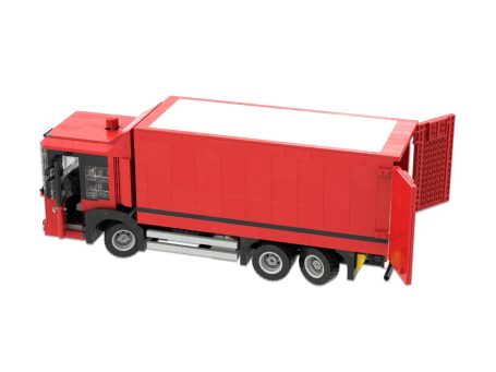 Camión de juguete rojo con caja contenedora y puertas traseras abiertas.