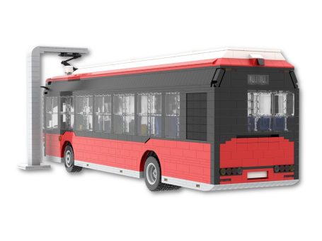 Autobús de juguete de bloques con tonos rojos y negros, junto a una estación de carga.