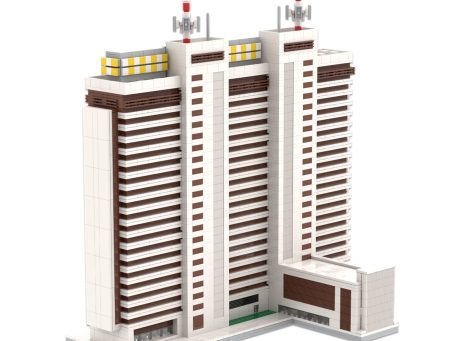 Edificio de gran altura con antenas en la azotea y ventanas amarillas.