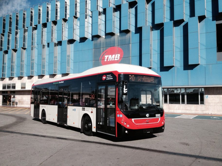 Autobús urbano de la ciudad frente a un edificio moderno.