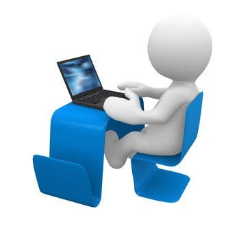 Figura de un hombrecito sentado en un escritorio azul usando una computadora portátil.